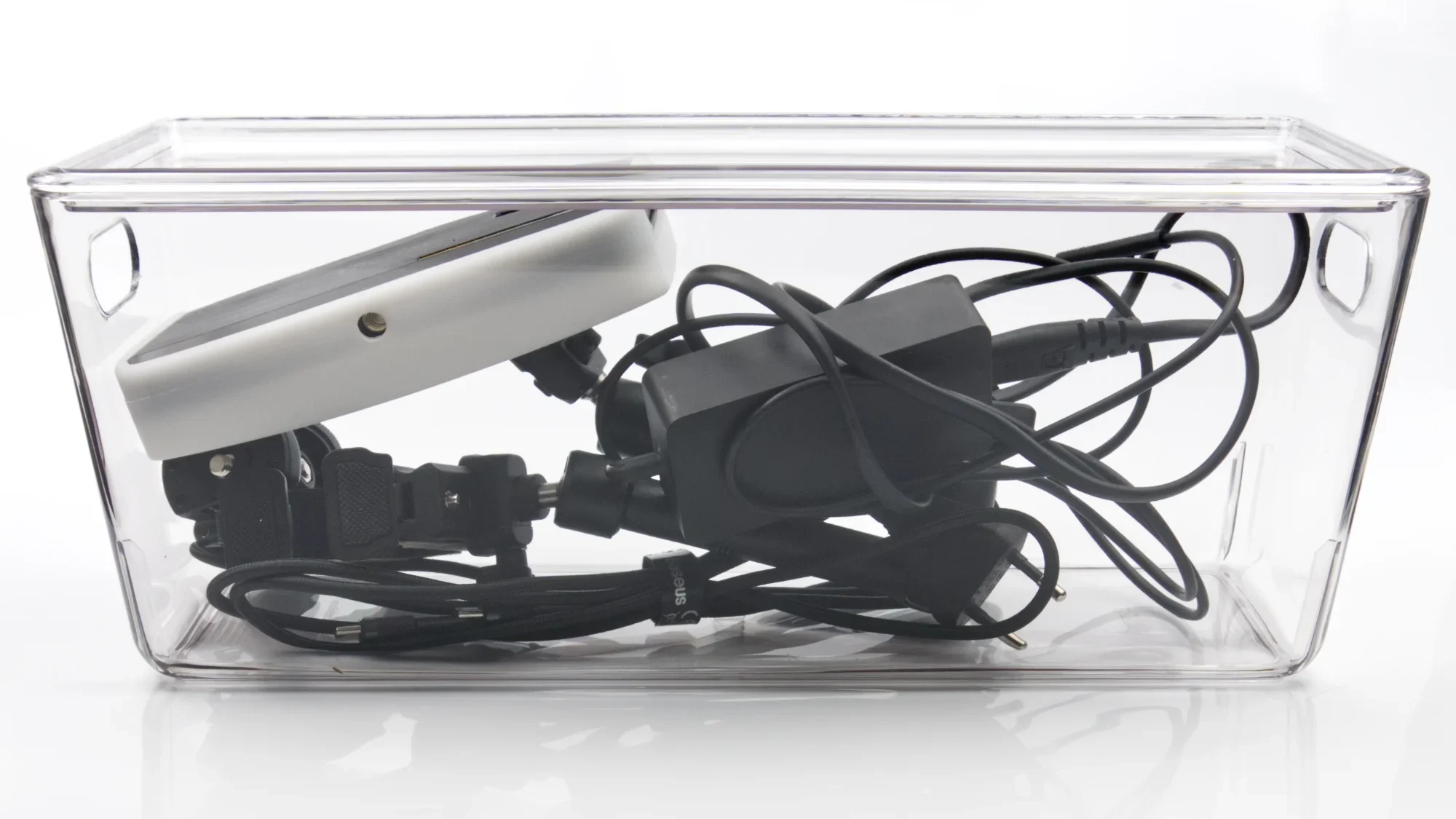 Gara caurspīdīga plastmasas uzglabāšanas kaste ar vāku, piepildīta ar vadiem un elektronikas piederumiem